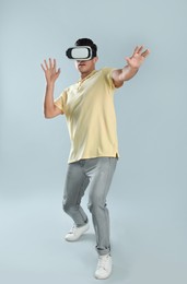 Man using virtual reality headset on grey background
