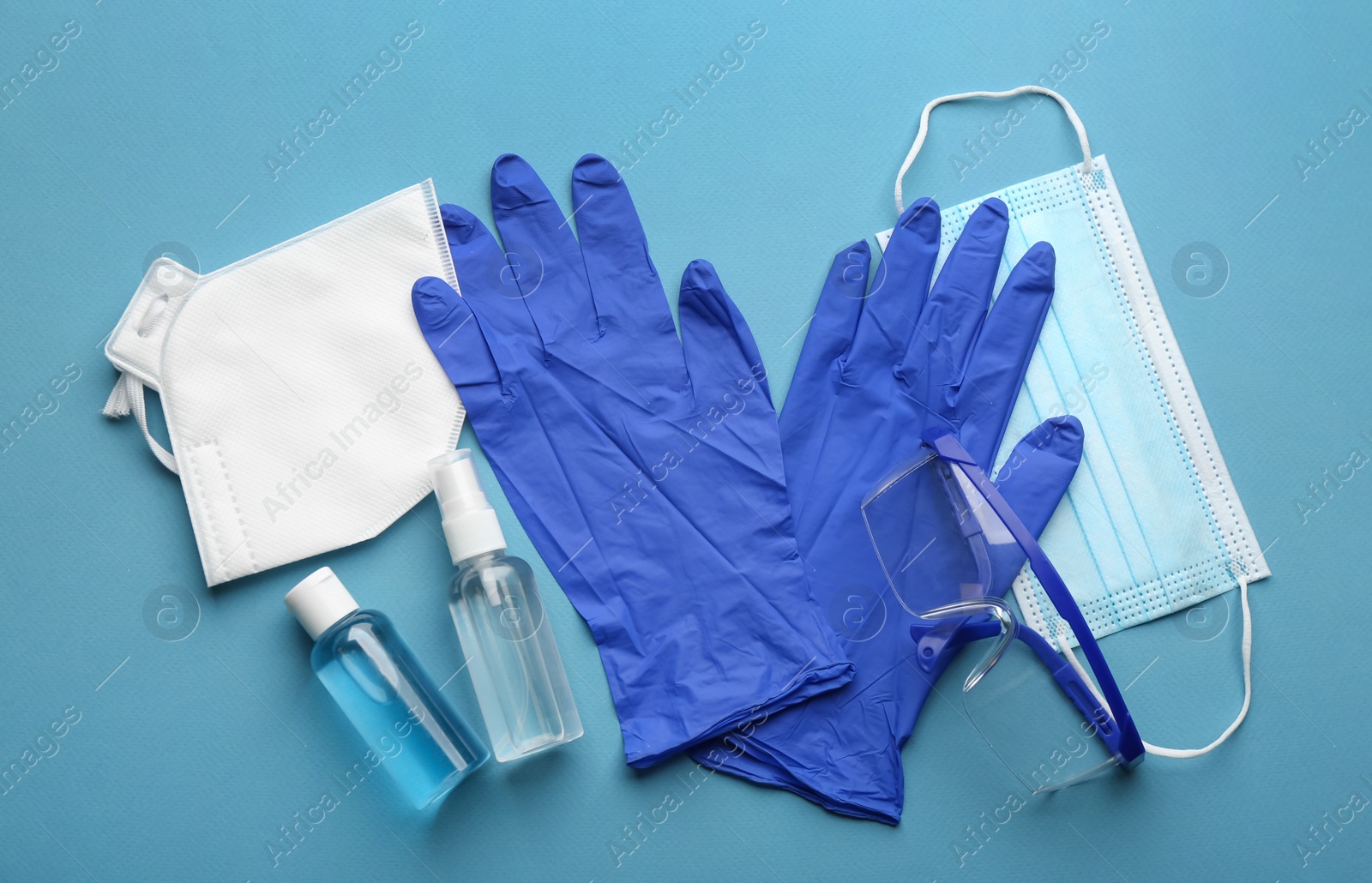 Photo of Flat lay composition with medical gloves, masks and hand sanitizers on blue background