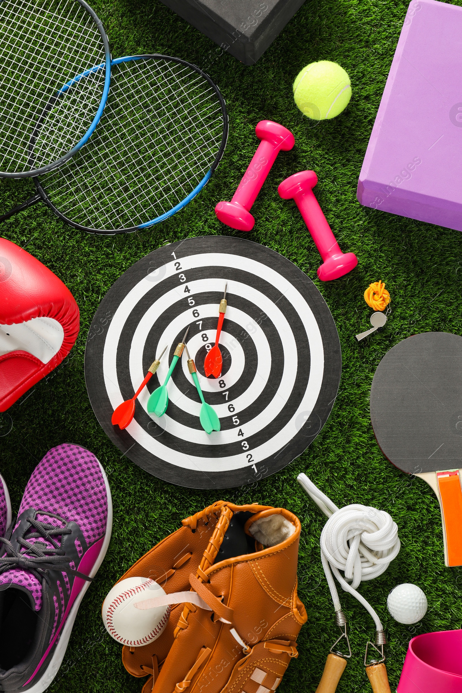 Photo of Different sport equipment on green grass, flat lay