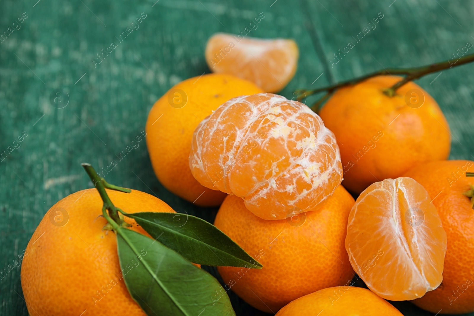 Photo of Fresh ripe tangerines with green leaves on table