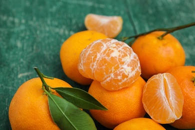 Fresh ripe tangerines with green leaves on table