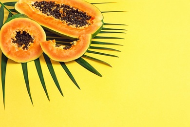 Flat lay composition with cut papaya on yellow background, space for text