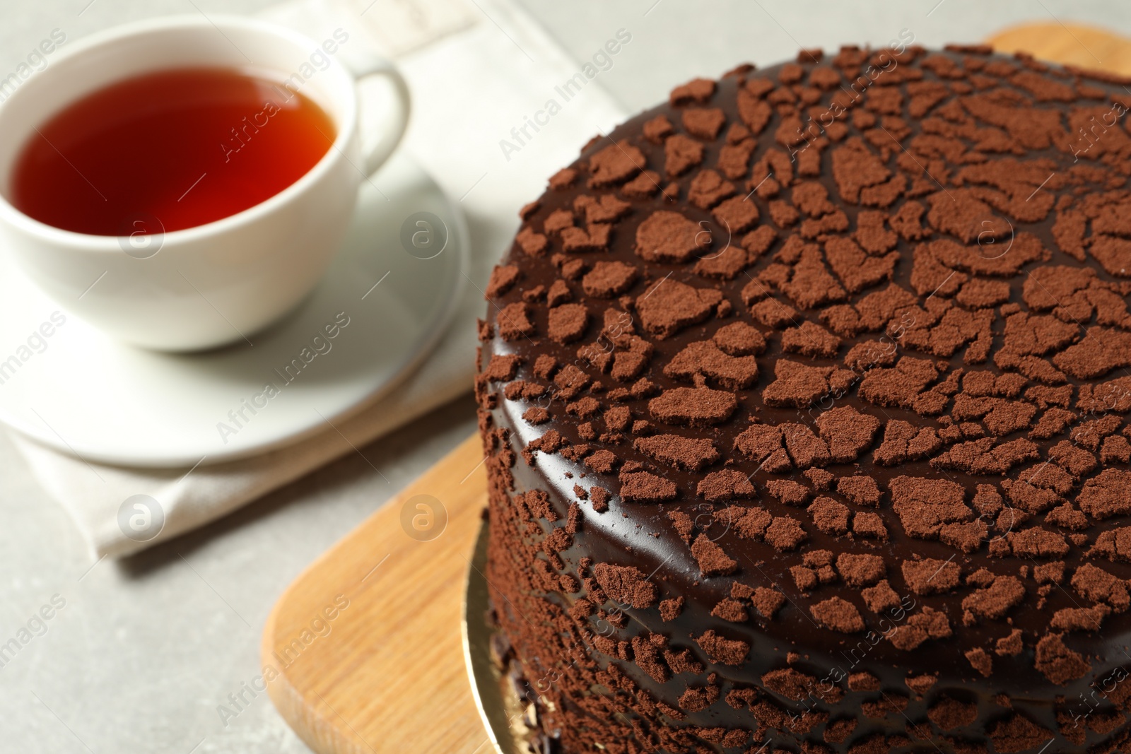 Photo of Delicious chocolate truffle cake and tea on light grey table