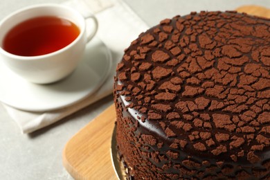 Delicious chocolate truffle cake and tea on light grey table