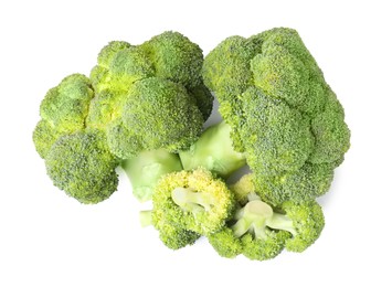 Photo of Pile of fresh raw green broccoli isolated on white, top view