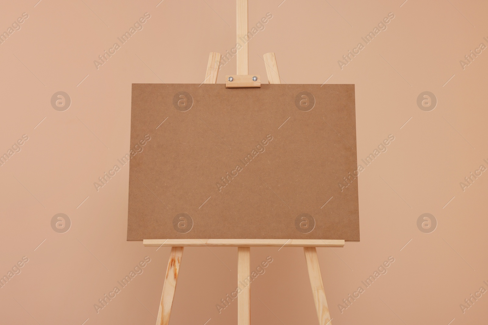 Photo of Wooden easel with blank board on beige background