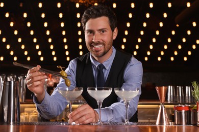 Photo of Bartender preparing fresh alcoholic cocktail in bar