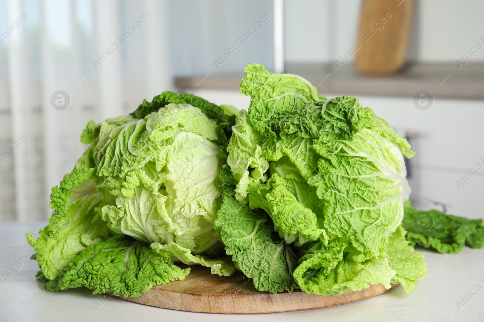 Photo of Fresh ripe Chinese cabbages on white table, closeup