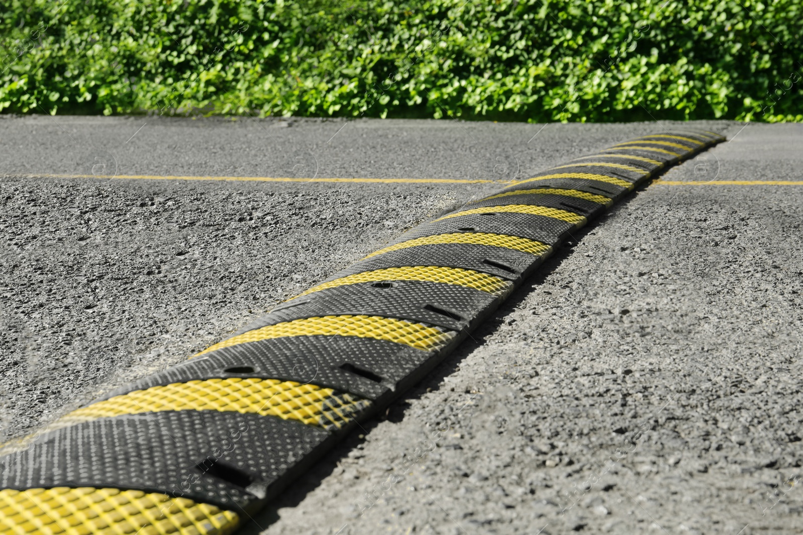 Photo of Speed bump on empty asphalt road. Traffic calming