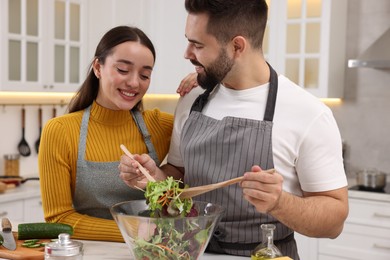 Photo of Lovely young couple cooking together in kitchen