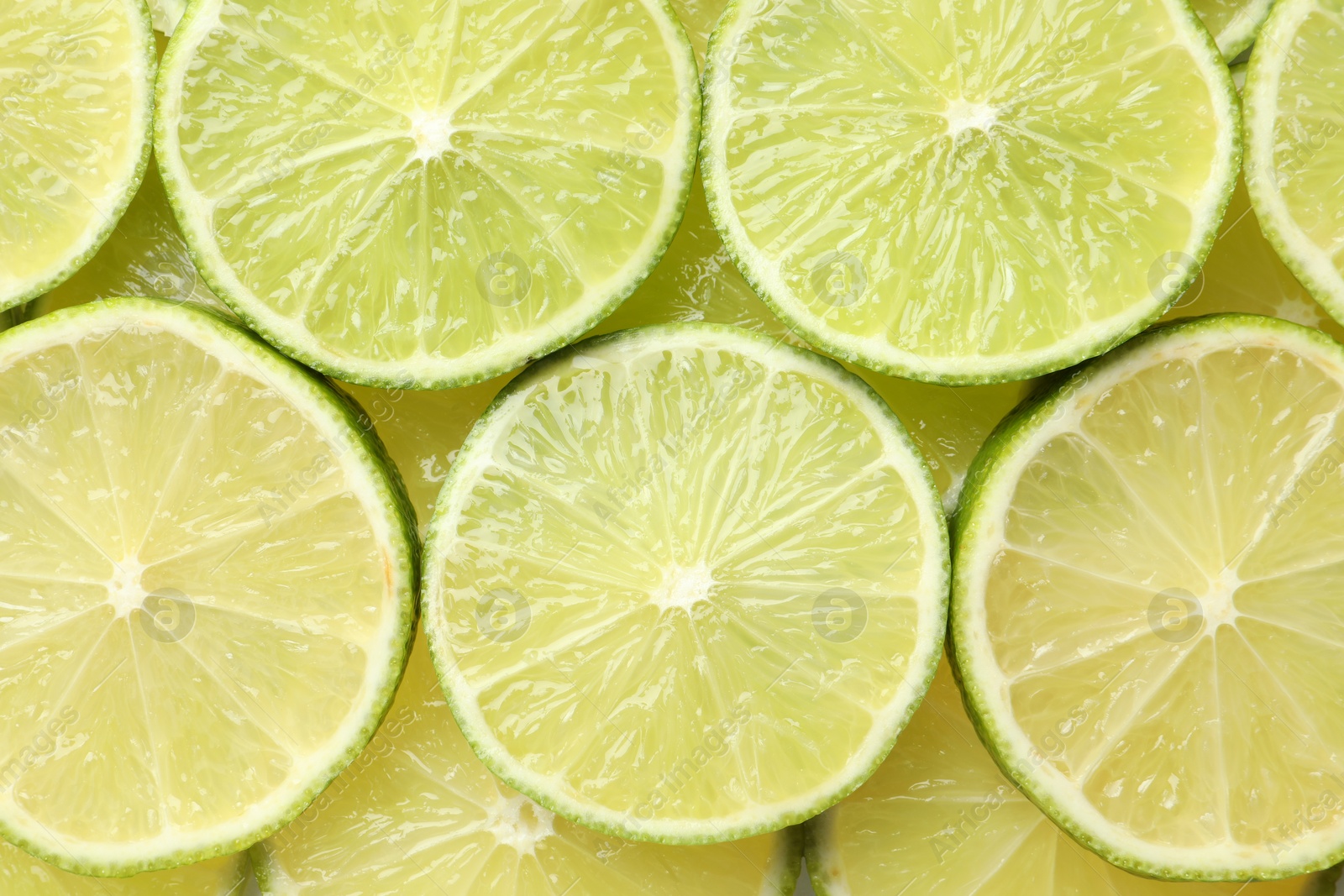 Photo of Fresh juicy lime slices as background, top view