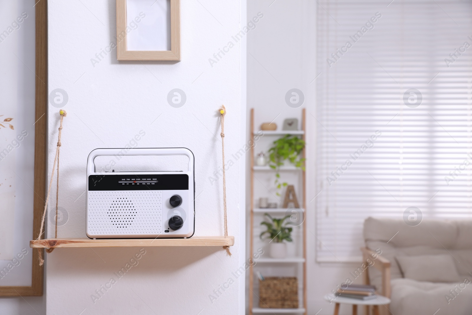 Photo of Stylish white radio on wooden shelf indoors, space for text