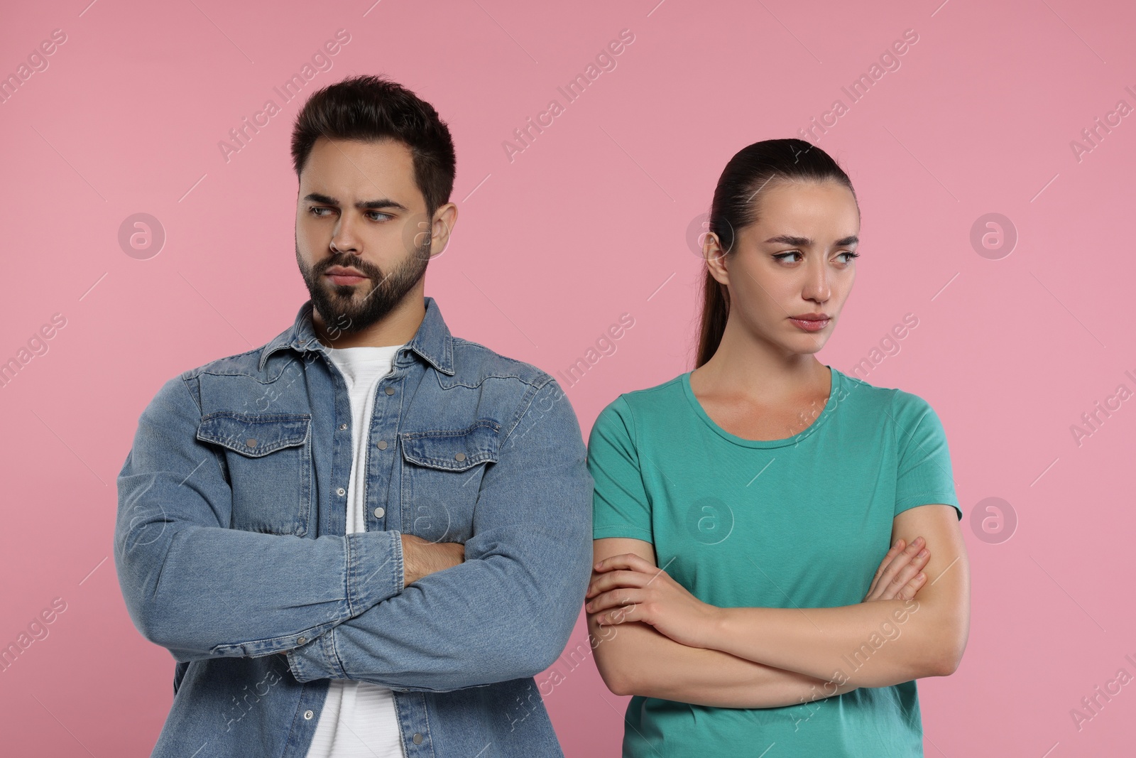 Photo of Resentful couple with crossed arms on pink background