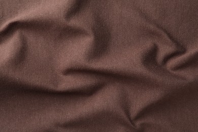 Photo of Texture of brown crumpled fabric as background, top view