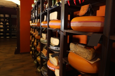 Different types of delicious cheeses on rack in store