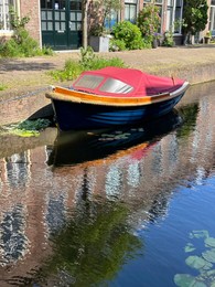 Photo of Canal with moored boat outdoors on sunny day