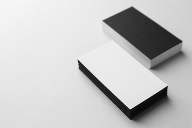 Photo of Blank black and white business cards on light background. Mockup for design