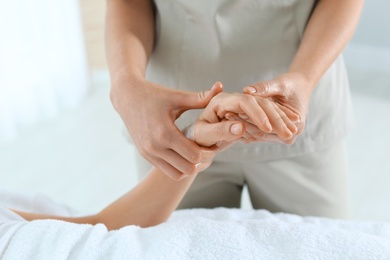 Photo of Woman receiving hand massage in wellness center, closeup