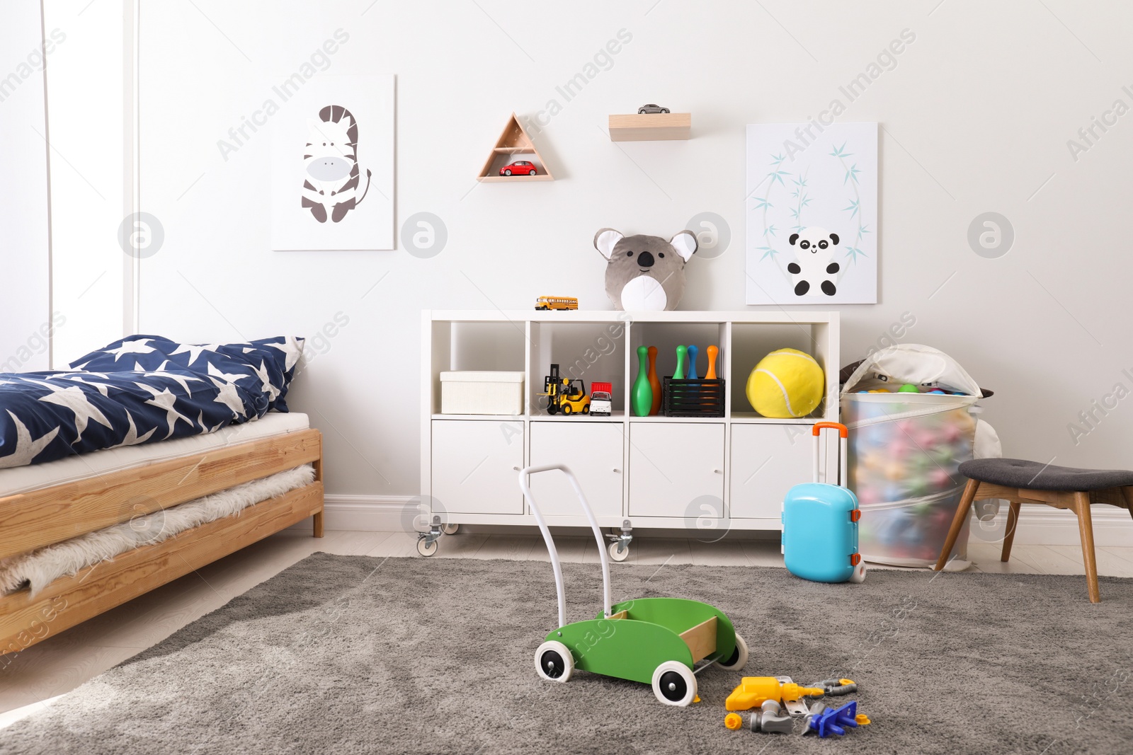 Photo of Cute child's room interior with toys and modern furniture