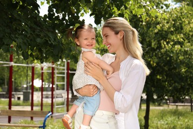 Happy mother with her daughter spending time together in park