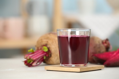 Glass with fresh healthy beet juice on table