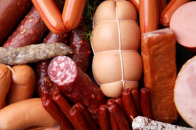 Different types of tasty sausages as background, top view