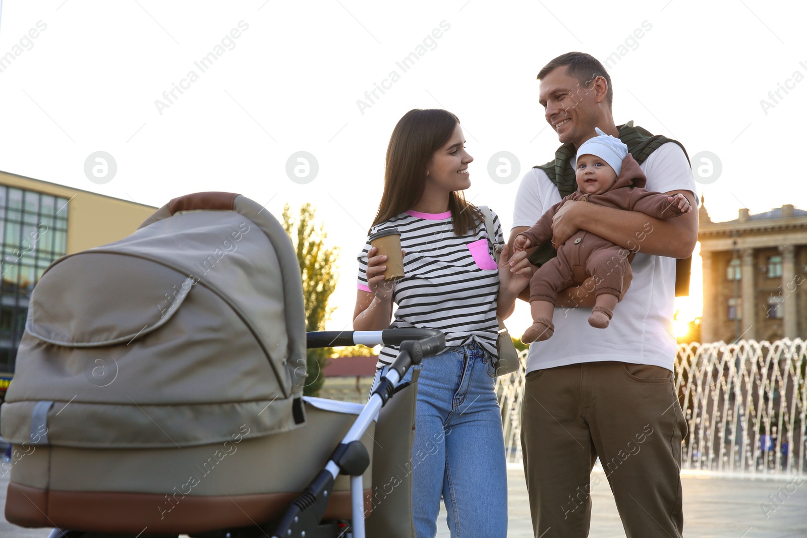 Photo of Happy parents walking with their baby outdoors