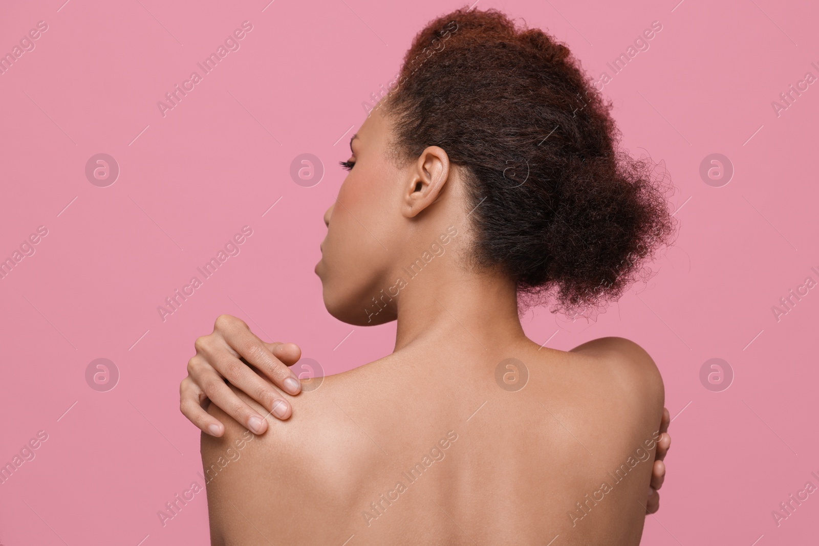 Photo of Beautiful young woman with stylish hairstyle on pink background, back view