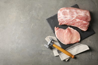Cooking schnitzel. Raw pork chops with meat mallet on grey table, flat lay and space for text