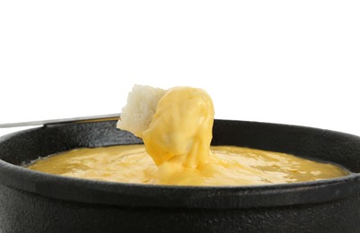Photo of Dipping piece of bread into fondue pot with tasty melted cheese isolated on white