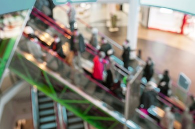 Photo of Blurred view of people on escalator in mall