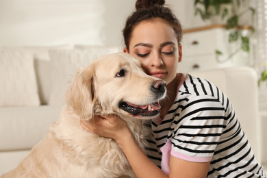 Young woman and her Golden Retriever at home. Adorable pet