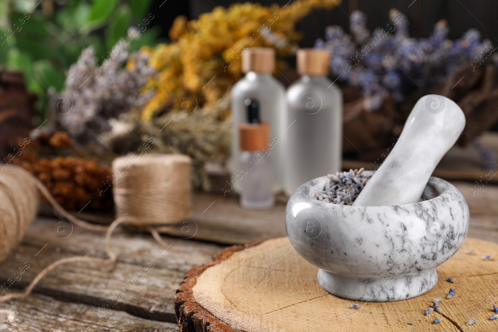 Photo of Mortar with pestle and lavender flowers on wooden table, space for text. Medicinal herbs