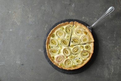 Photo of Tasty leek pie with cake server on dark textured table, top view. Space for text