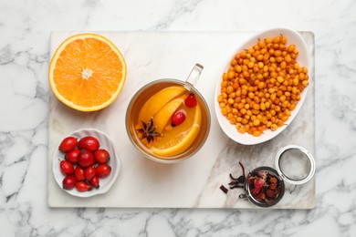 Immunity boosting drink and ingredients on white marble table, top view