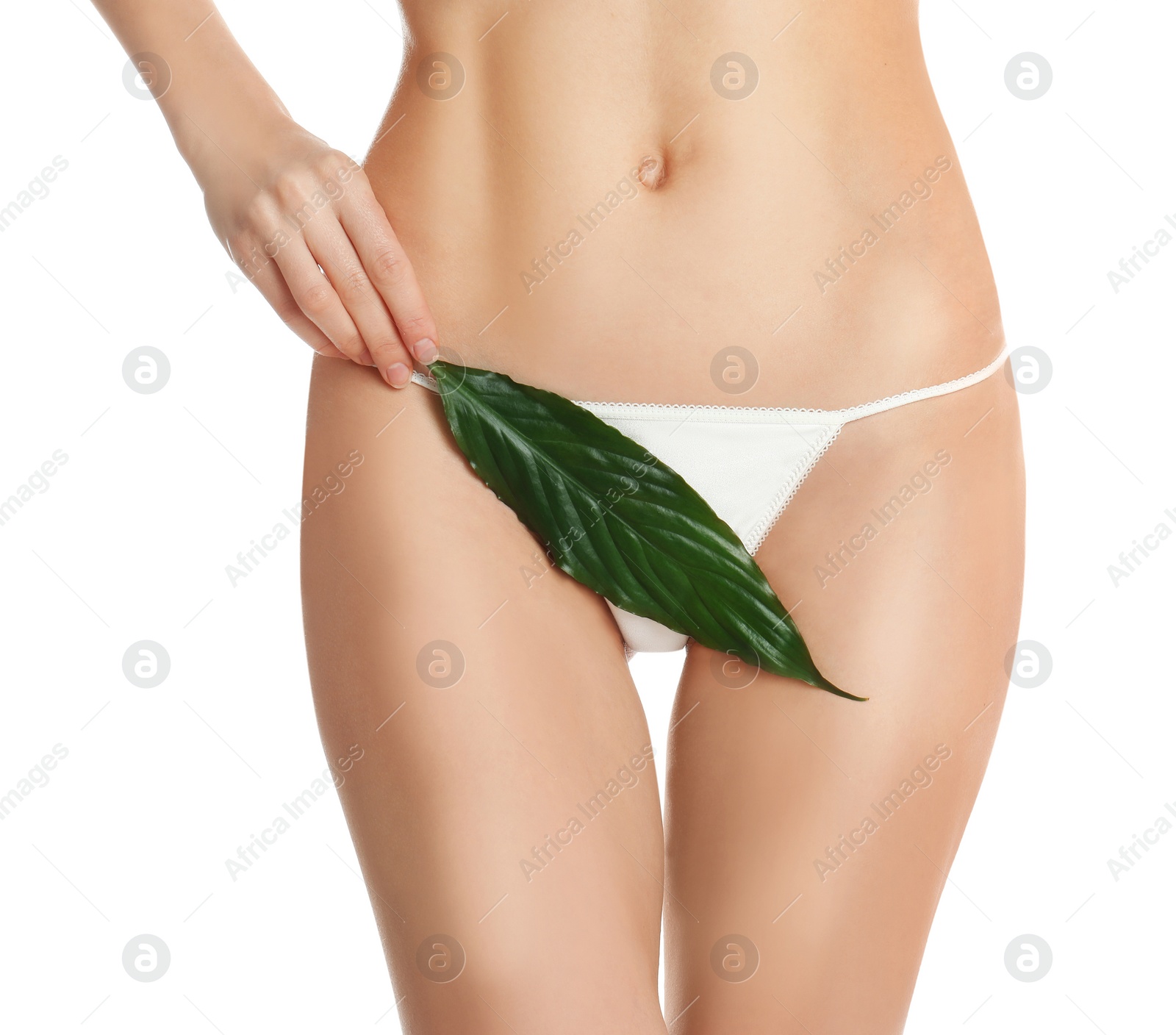 Photo of Woman with leaf showing smooth skin after Brazilian bikini epilation on white background, closeup. Body care concept