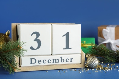 Photo of Block calendar and Christmas decor on blue background. New Year countdown