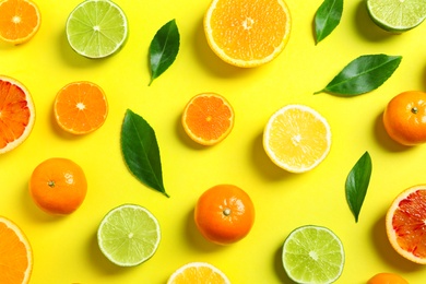 Photo of Different citrus fruits and leaves on color background, flat lay