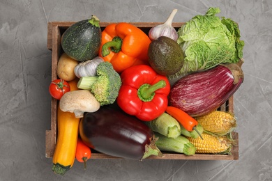 Photo of Crate with different fresh vegetables on grey background, top view
