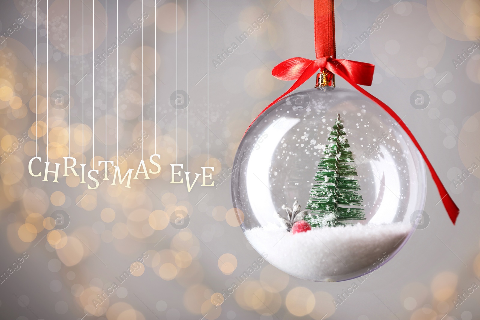 Image of Christmas Eve, postcard design. Decorative bauble against blurred festive lights 