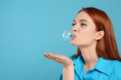 Photo of Beautiful woman blowing bubble gum on turquoise background, space for text
