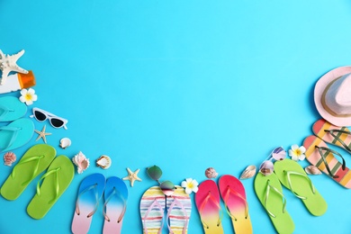 Photo of Flat lay composition with different flip flops on blue background, space for text. Summer beach accessories