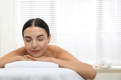 Beautiful young woman relaxing in spa salon