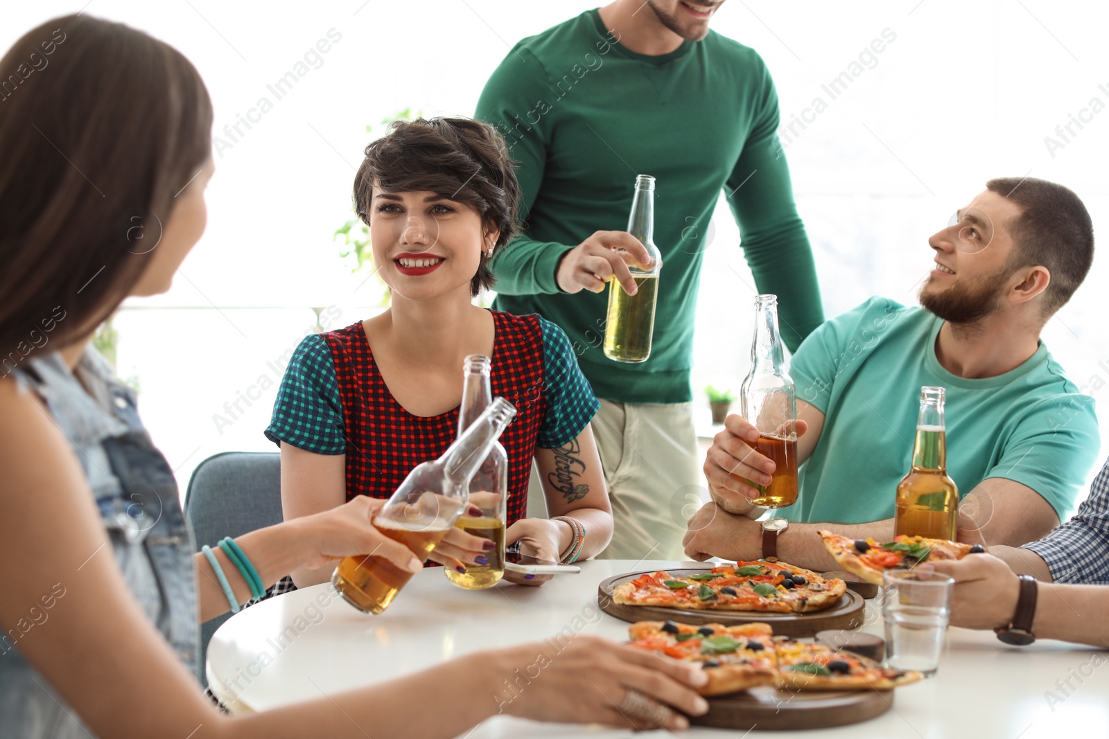 Photo of Young people having fun party with delicious pizza indoors