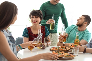 Young people having fun party with delicious pizza indoors