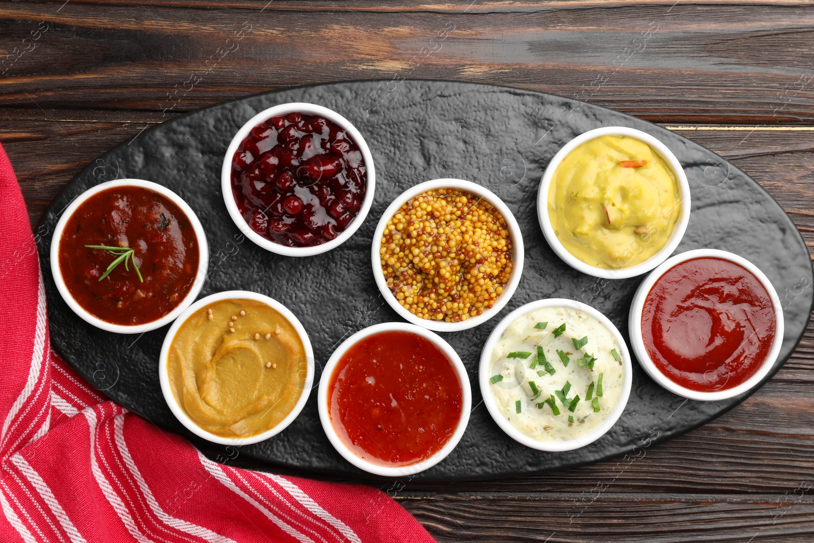 Photo of Different tasty sauces in bowls on wooden table, top view