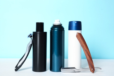 Photo of Shaving accessories for men on table against color background