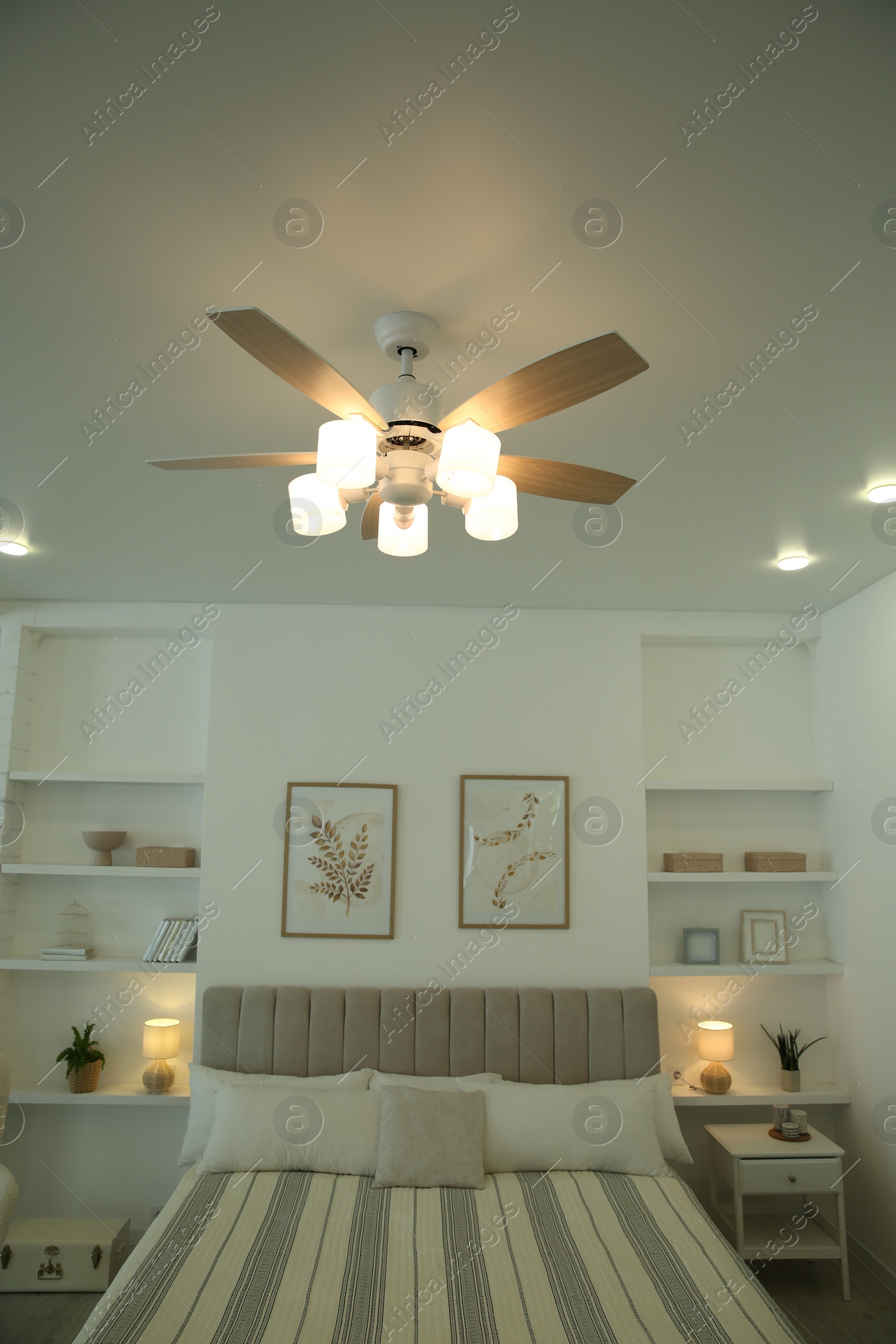 Photo of Ceiling fan, furniture and accessories in stylish bedroom