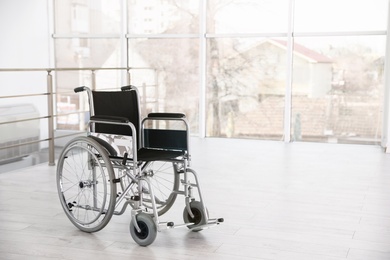 Photo of Modern wheelchair in empty room, space for text. Medical equipment