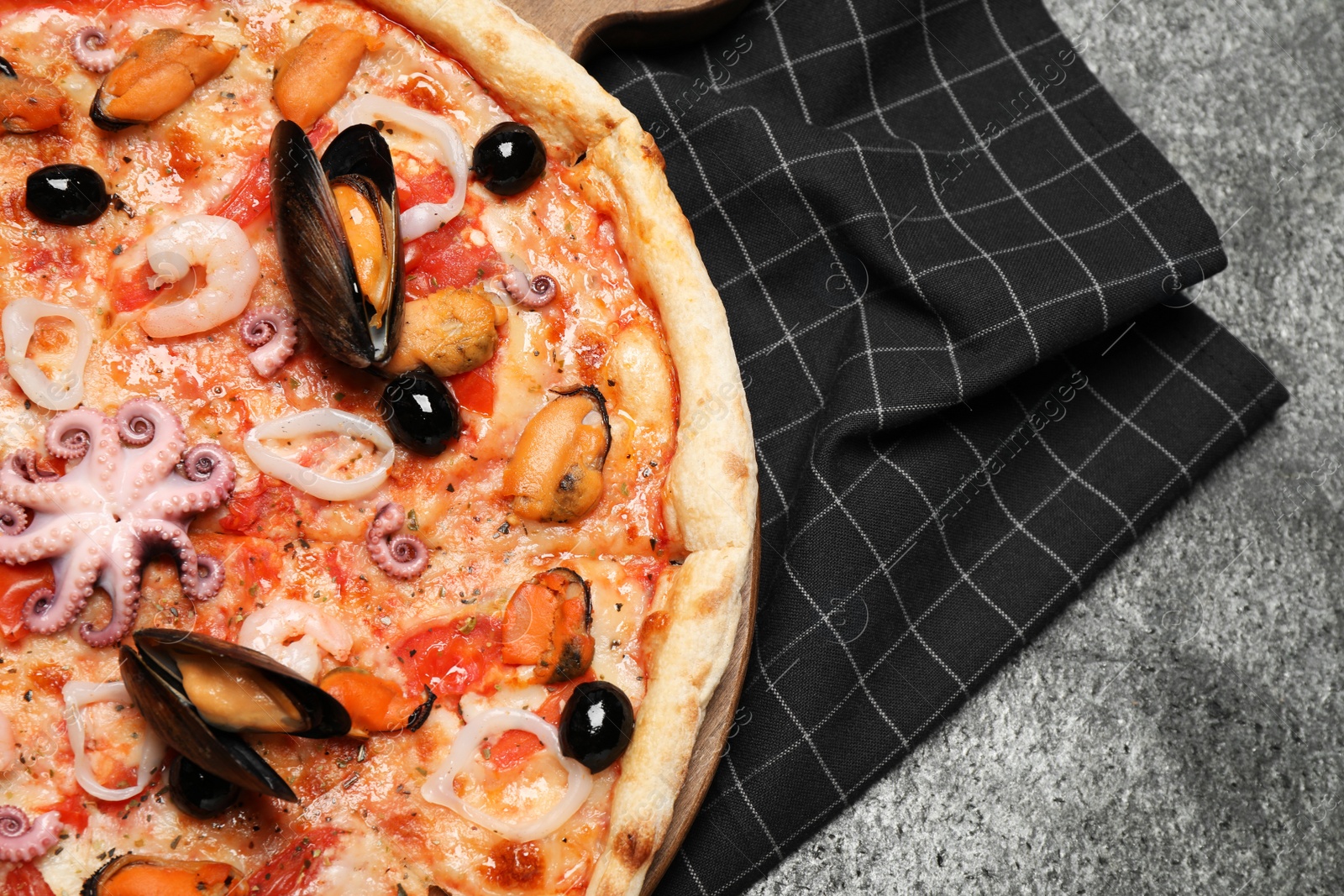 Photo of Tasty pizza with seafood on grey table, top view